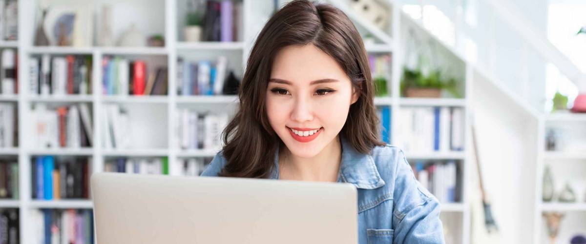 Smart asian young girl student feel satisfied during internet online courses and searching information via laptop computer at home