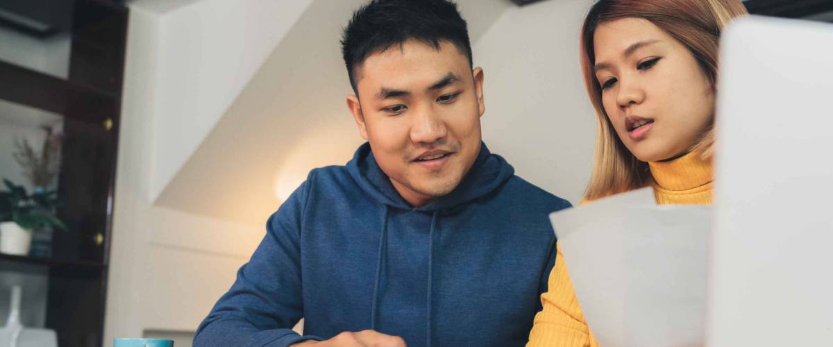 Young asian couple managing finances, reviewing their bank accounts