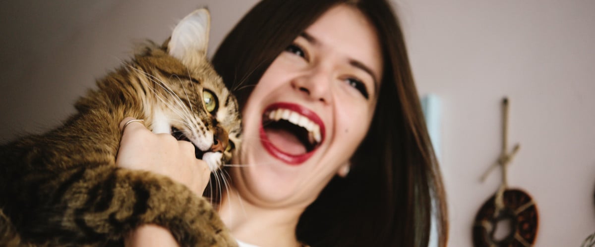 Woman smiling holding a cat