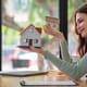 Women support model houses with two hands and give the house over to customers or homebuyers. Rent and buy home or Real Estate Buying Ideas and Investment Banking Finance concept.