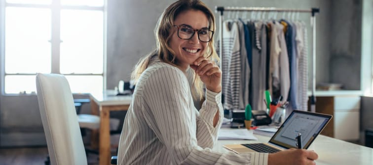 Young woman smiling and taking notes at desk