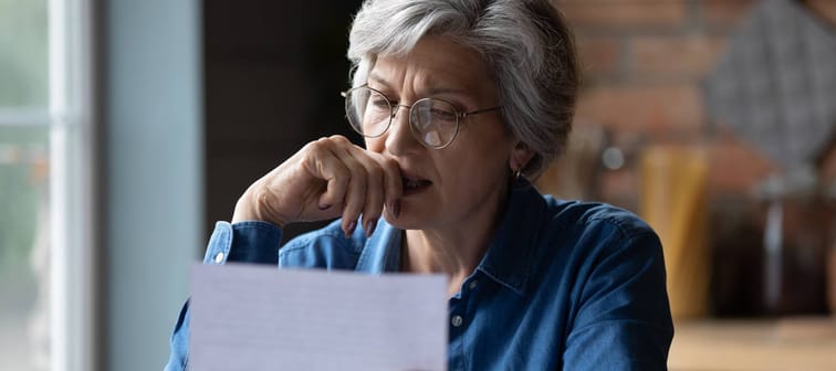 Woman receiving distressing news in a letter.