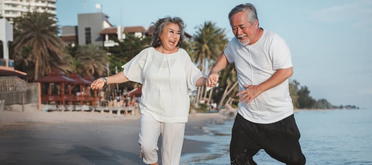 Older couple running on beach