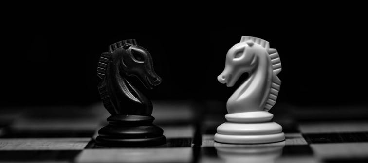 two knights on a chessboard facing off against each other