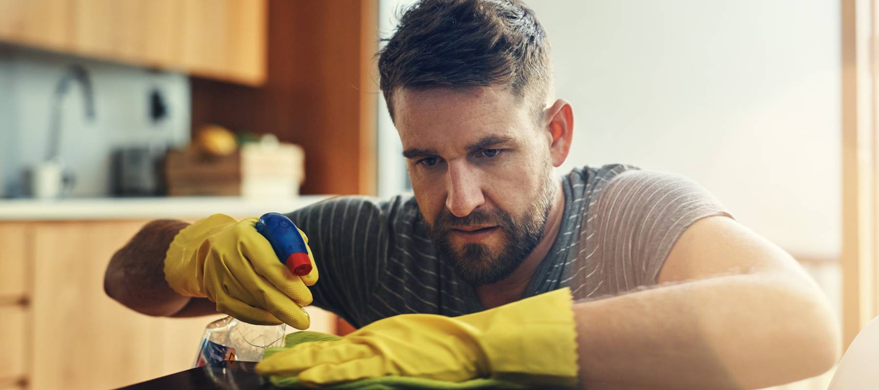 Middle-aged man cleaning kitchen counter