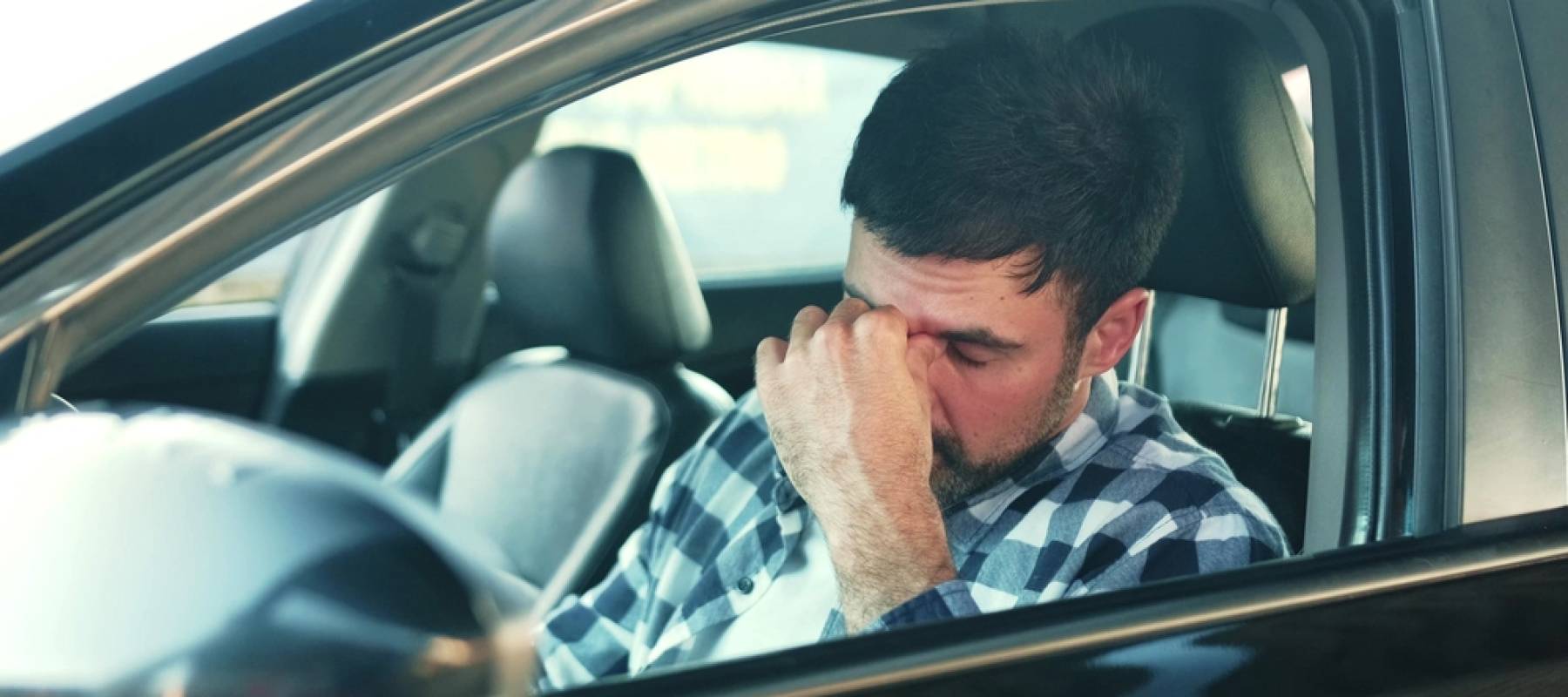 Man looks stressed in car