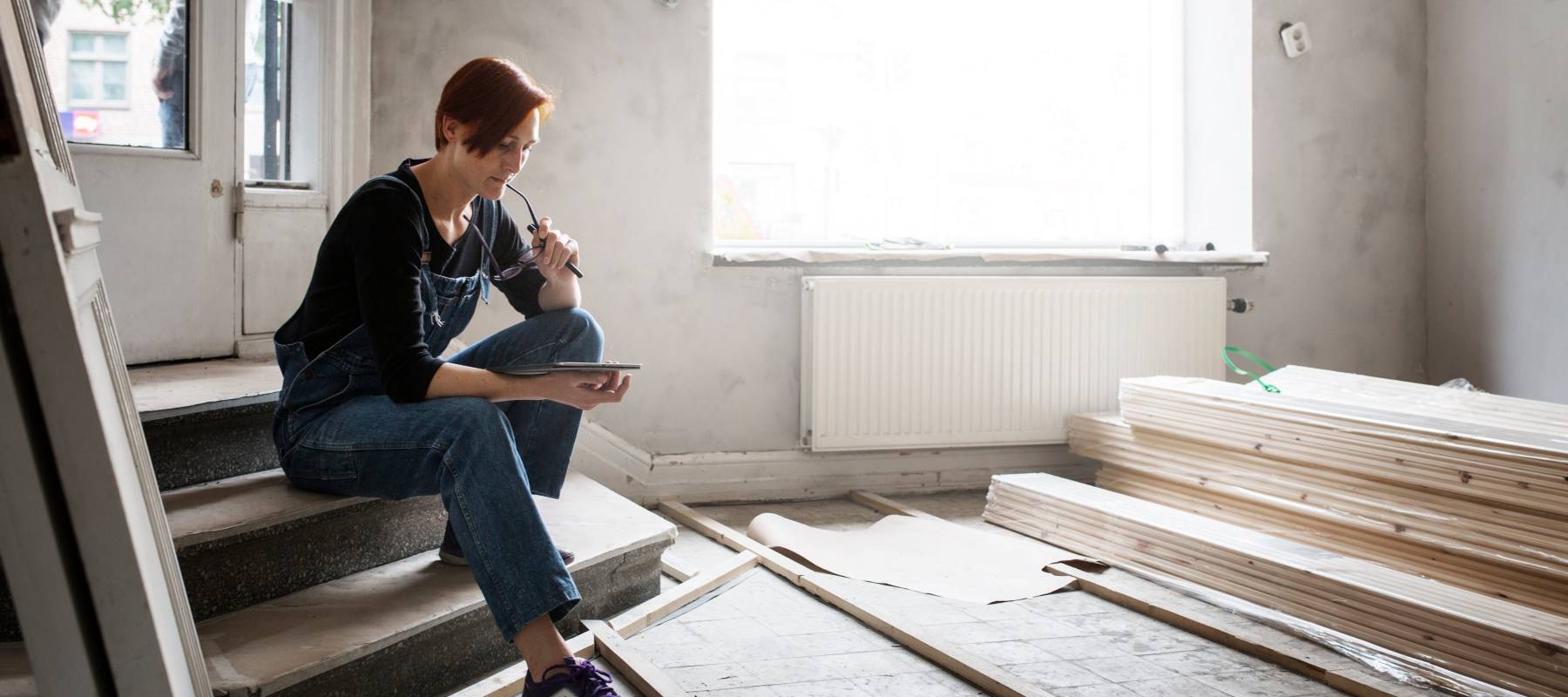 Woman looking at her phone while renovating her home
