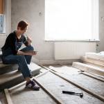 Woman looking at her phone while renovating her home