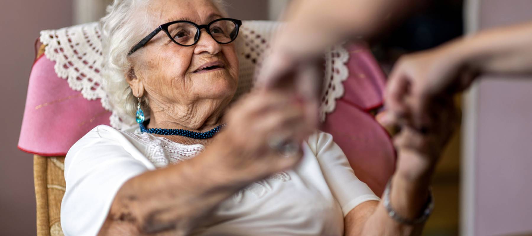 home carer supporting old woman to stand up