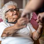 home carer supporting old woman to stand up