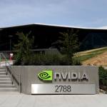 sign is posted in front of the Nvidia headquarters as employees walk up a set of stairs.