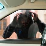 man breaking into car