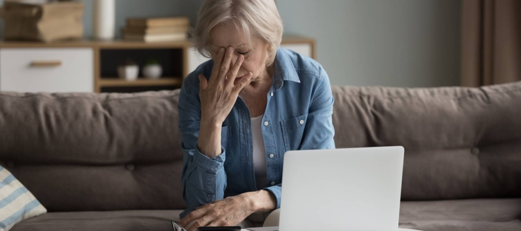 Woman crunching numbers on couch