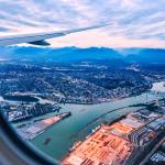 View from airplane window on fields in wing with top view of Vancouver