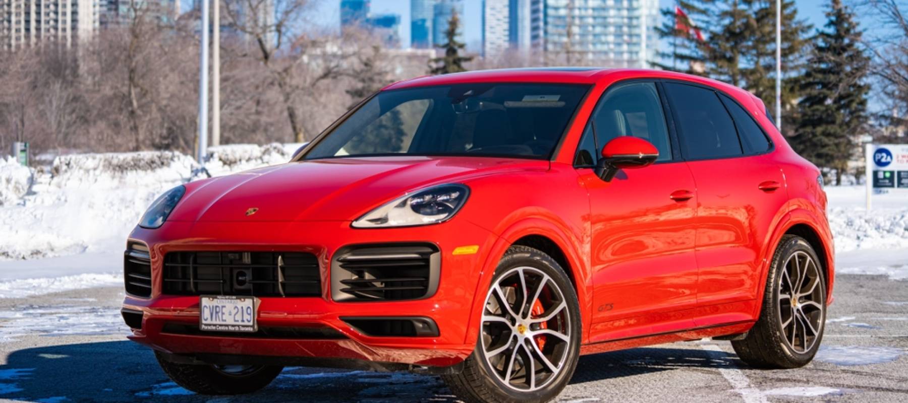 A Red Porsche Cayenne in a parking low on a sunny day during the winter