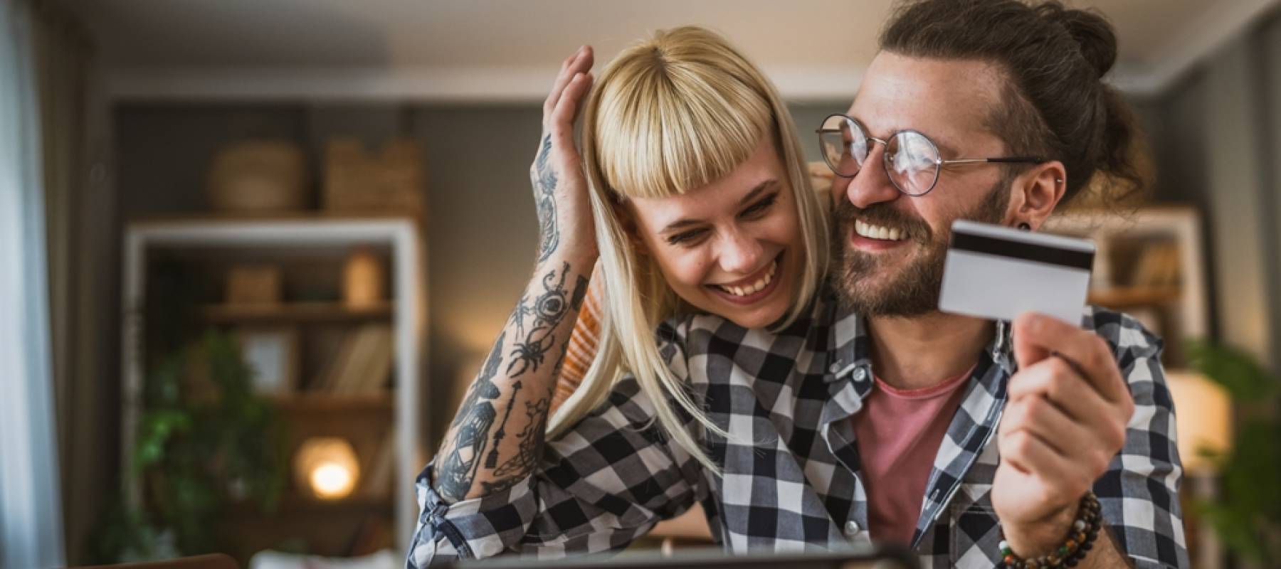 Happy couple paying credit card debt