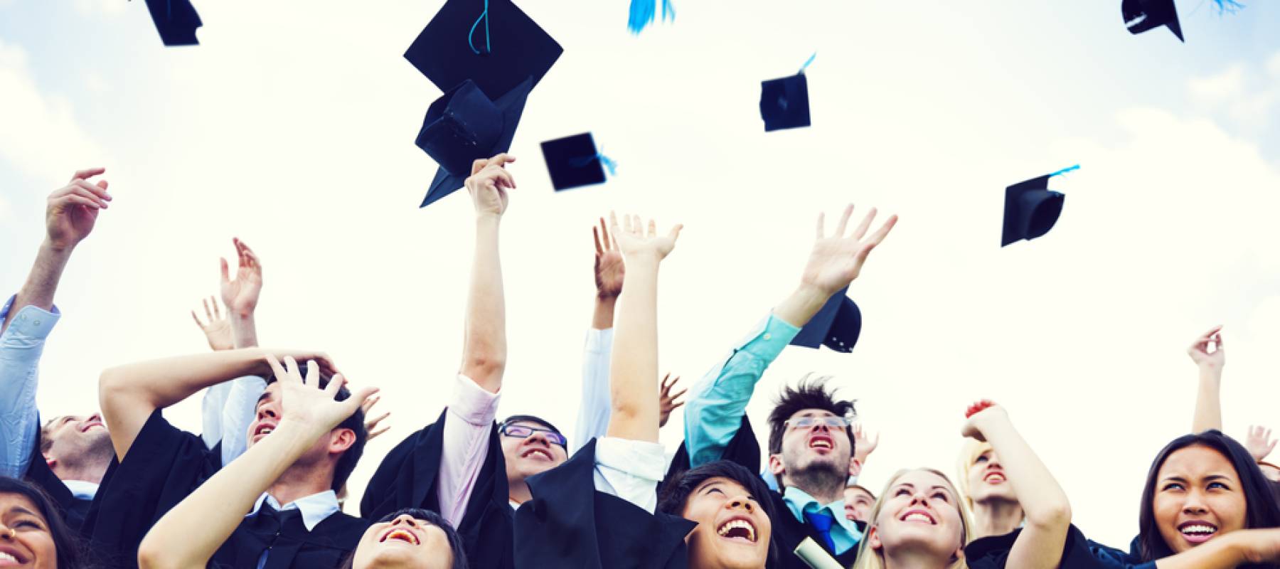 Graduating students throwing caps in the air