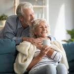 Affectionate senior couple enjoying cozy moment on a couch.