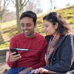 Toronto, Ontario, Canada - April 05, 2021, Cheerful lovely Indian immigrant newcomer couple, at park sitting on bench