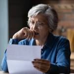 Woman receiving distressing news in a letter.