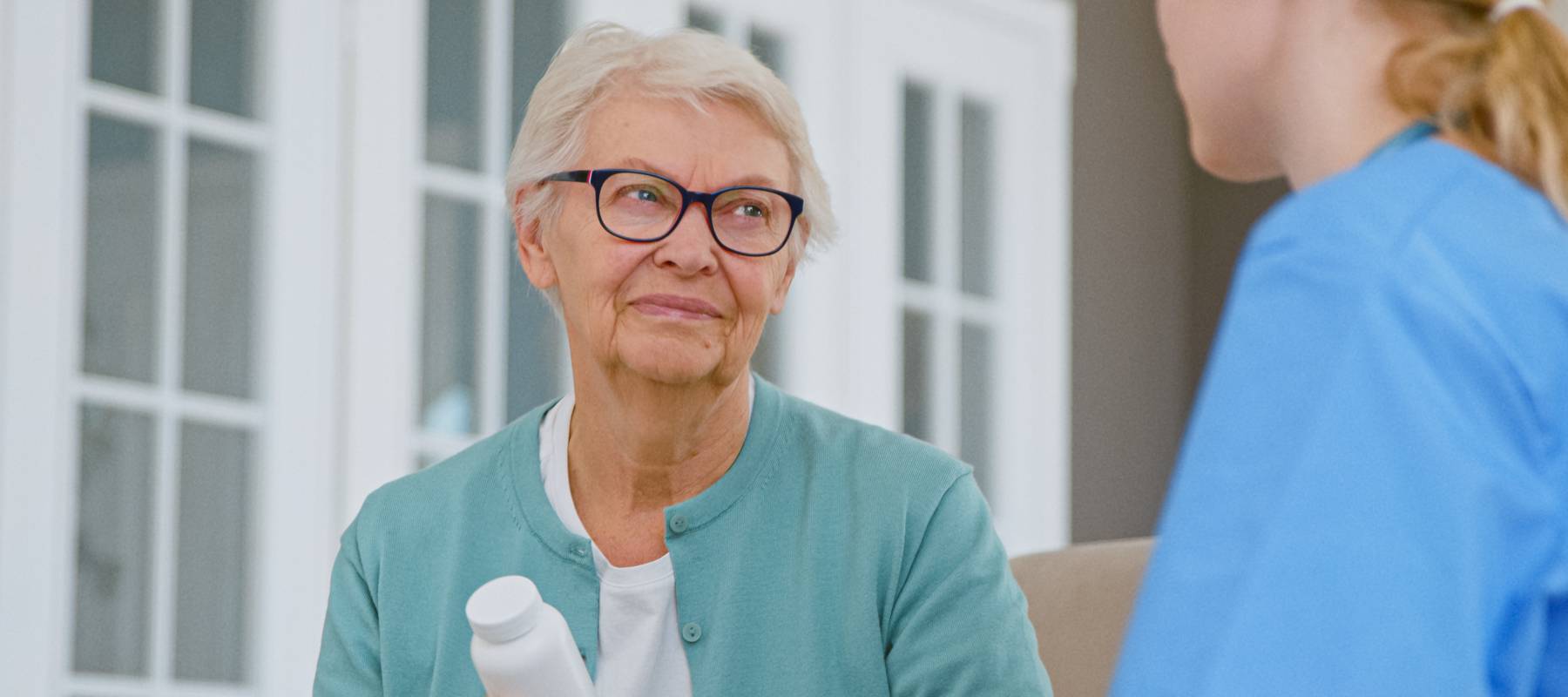 Elderly woman discussing medication with nurse
