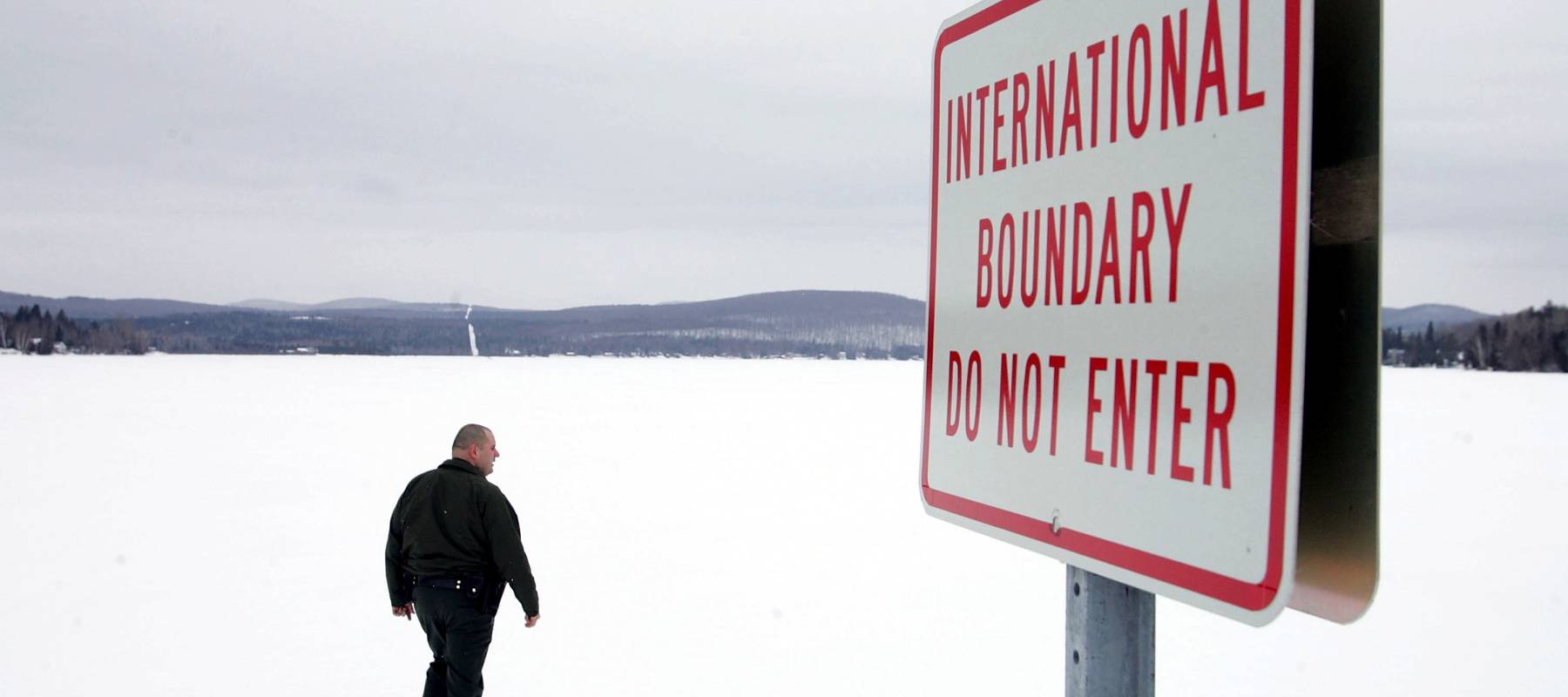 U.S. Border Patrol Agent Andrew Mayer walk near the Canadian border near Norton, Vermont