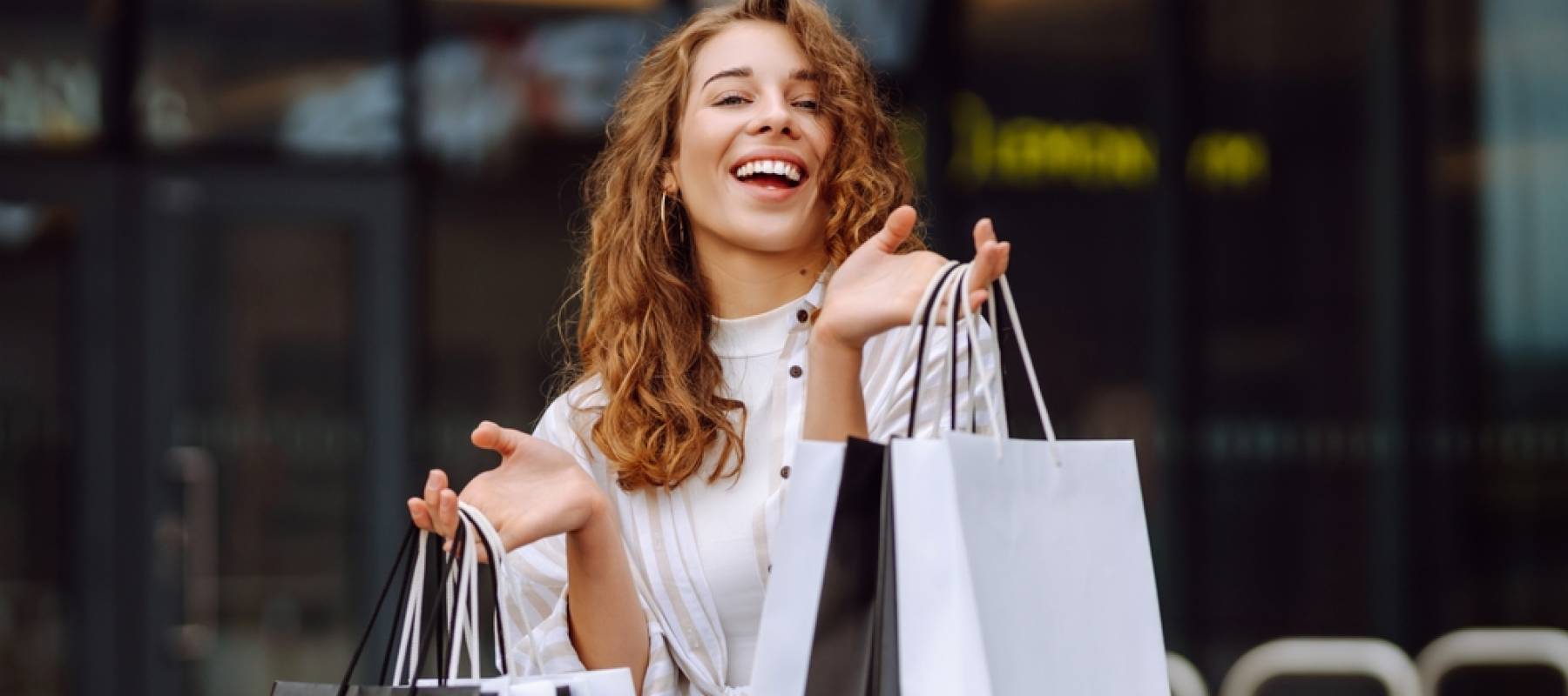 Woman smiling with many shopping bags