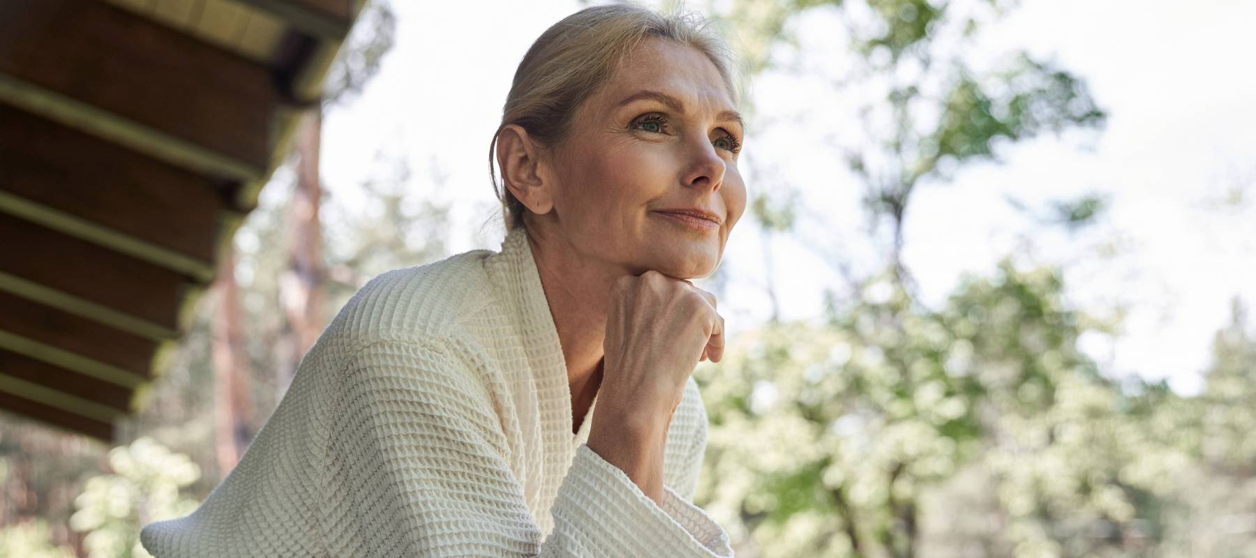 Older retired woman in dressing gown enjoying morning coffee