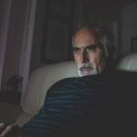 Older man looking at laptop in the dark