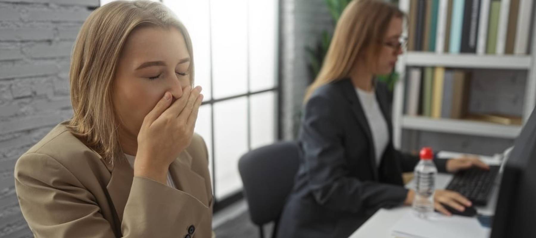 Woman yawning at her desk