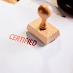 Red certified rubber stamp on white sheet of paper. Law office.