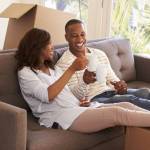 Couple On Sofa Taking A Break From Unpacking On Moving Day