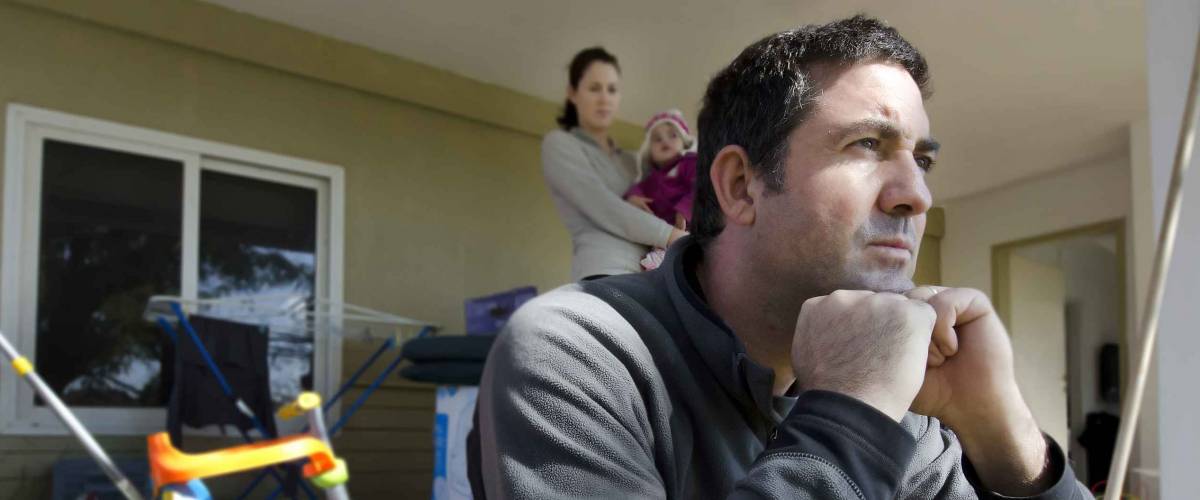 Upset young parents and their daughter outside their home.