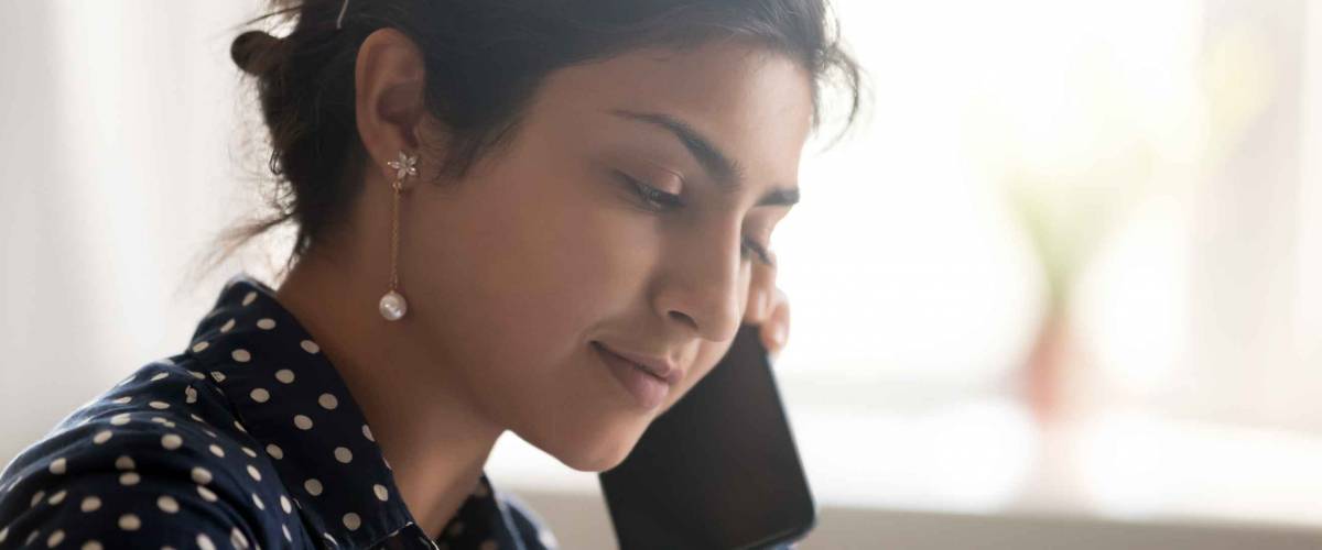 Close up portrait indian young female talking by mobile phone