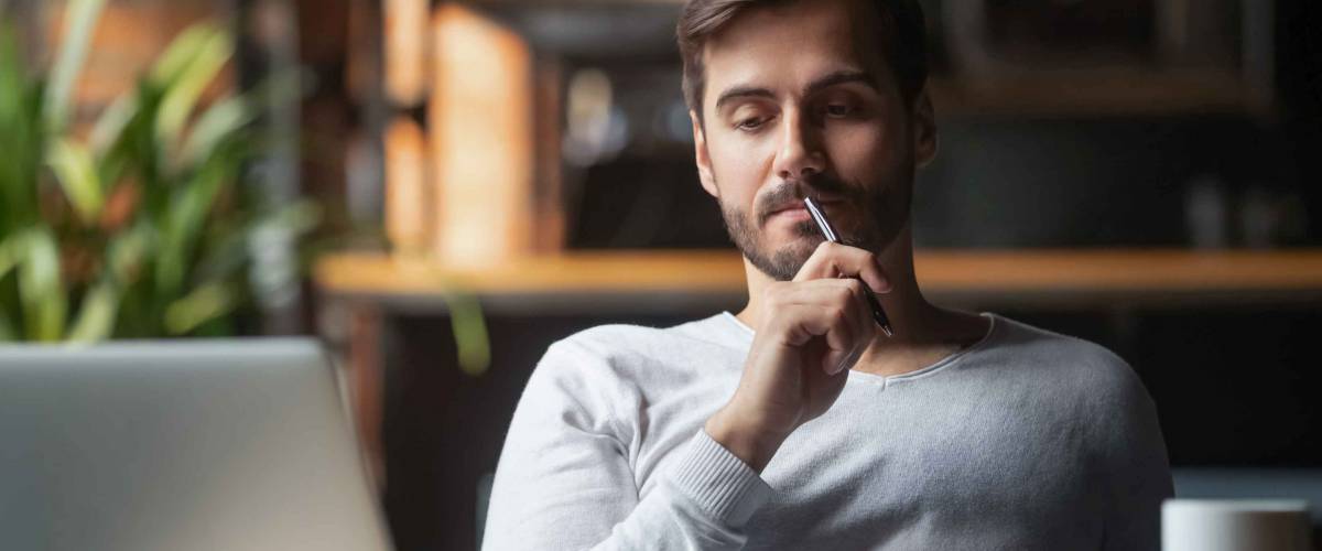 Pensive bearded man sitting at table