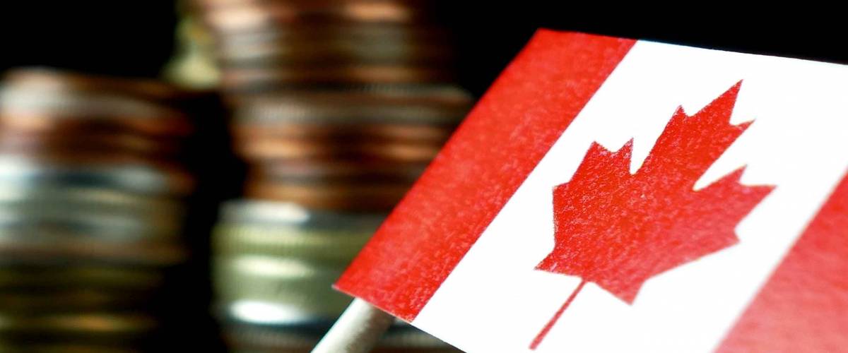 Canada flag waving with stack of money coins macro