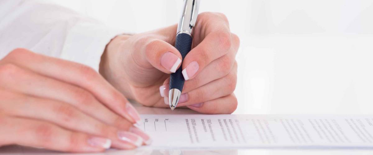 Close-up Of A Female's Hand Filling Form
