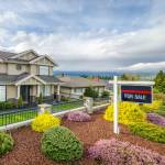 House For Sale Real Estate Sign in Front of a House.