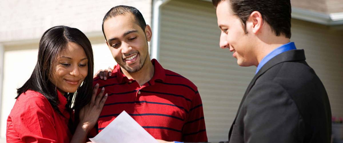 Real Estate: Agent Shows Information To Couple