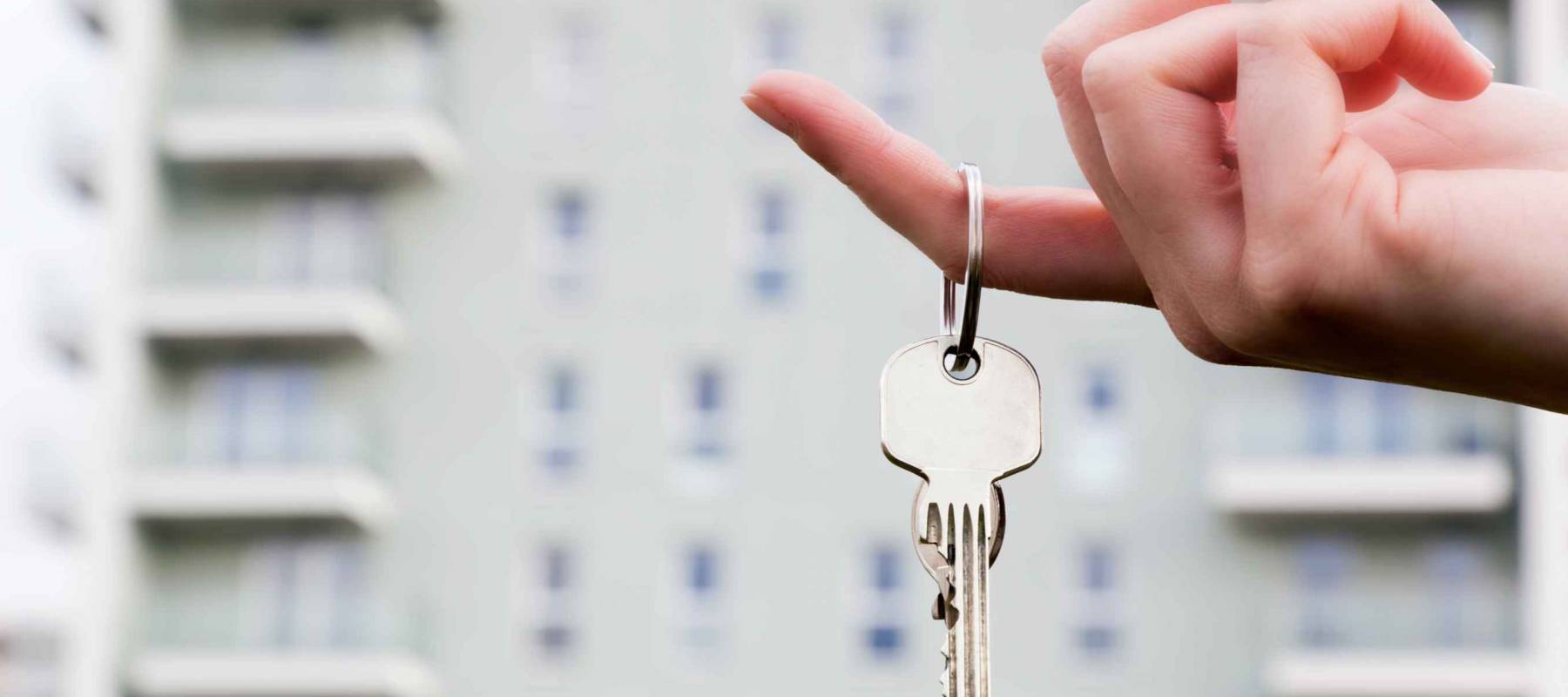 A real estate agent holding keys to a new apartment in her hands. Real estate industry
