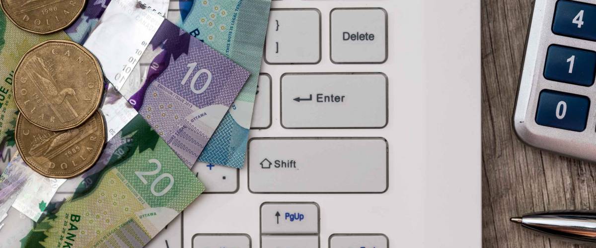 Canadian dollar with laptop  - business concept