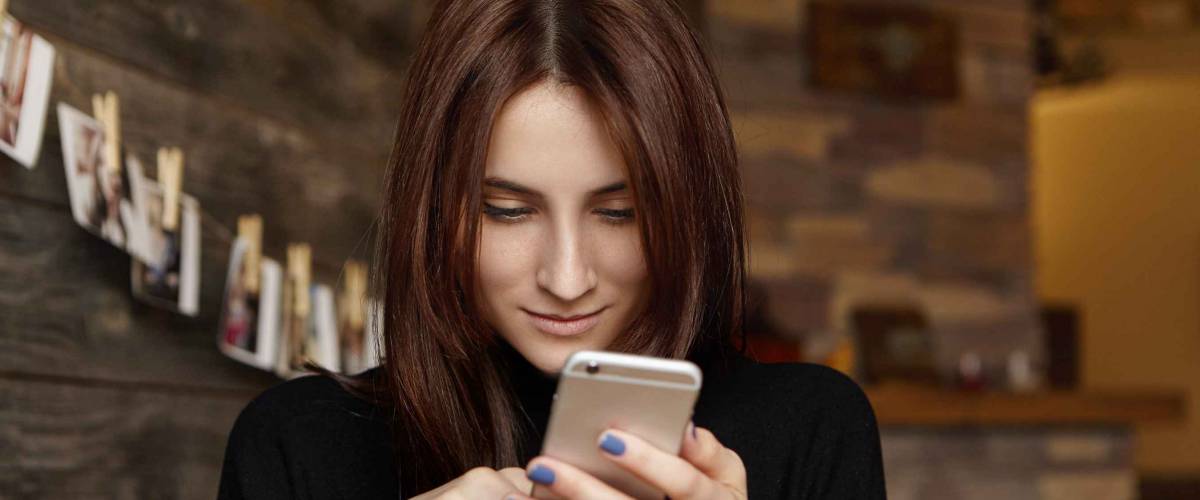 Young woman looking at cellphone casually