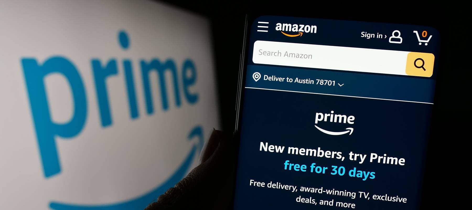 Person holding cellphone with webpage of subscription service Amazon Prime in front of business logo.