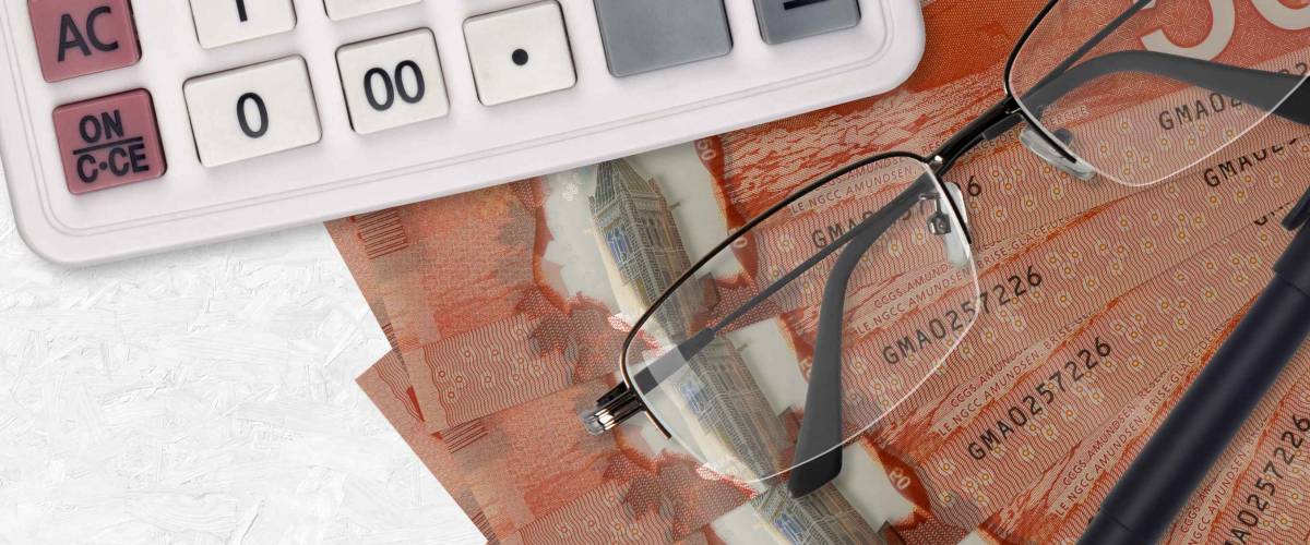 50 Canadian dollars bills fan and calculator with glasses and pen. Business loan or tax payment season concept. Financial planning