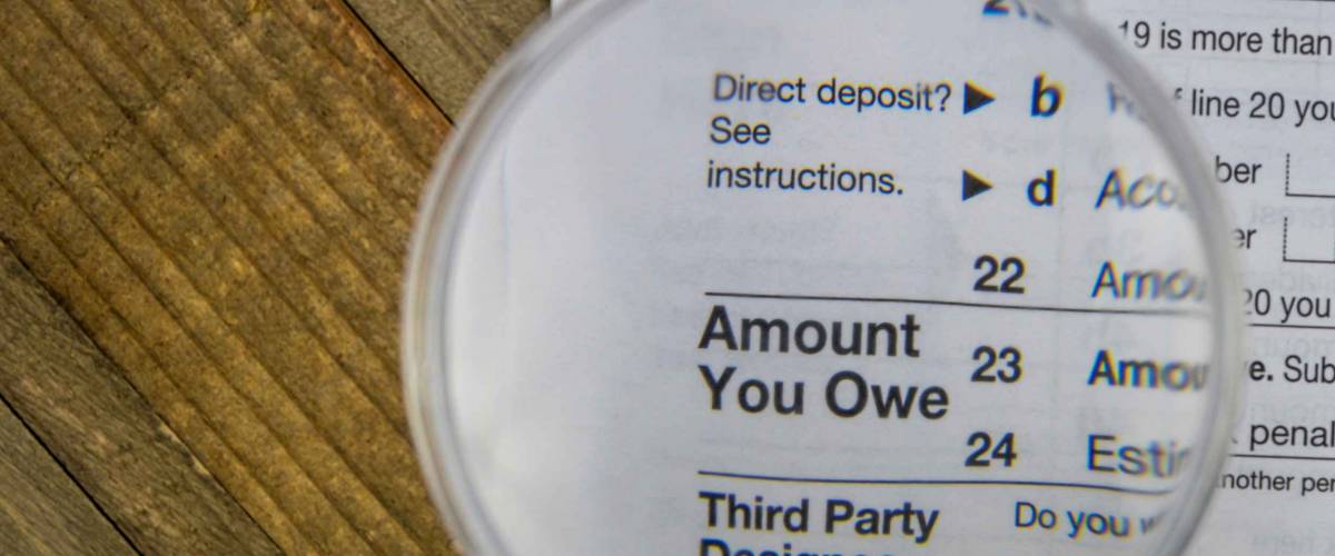 Tax Form 1040 AMOUNT YOU OWE business concept flat lay wooden board