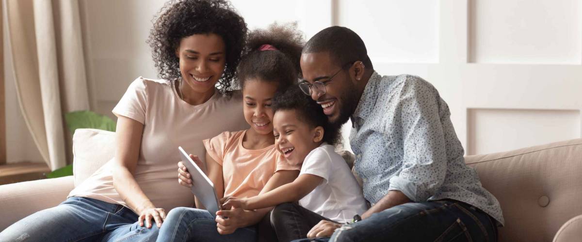 Happy family having fun with device at home