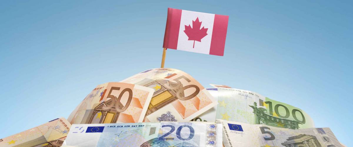 The national flag of Canada sticking in a pile of mixed european banknotes.(series)