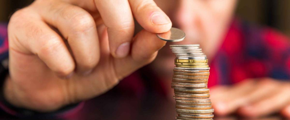 Man counts his coins on a table. Personal finance, finance management, savings, thrifty or avarice concept.