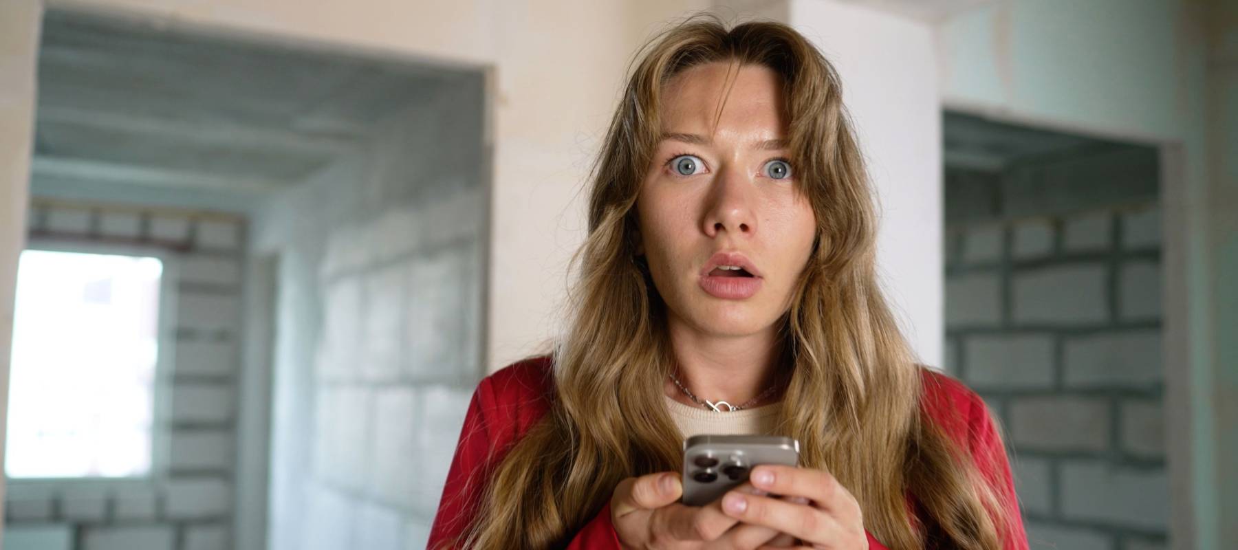 Shocked woman reading bad news on smartphone