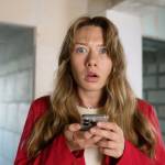Shocked woman reading bad news on smartphone